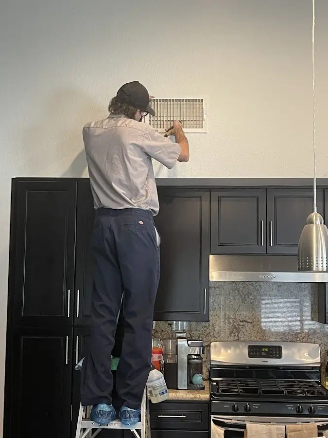 Technician inspecting an air vent during HVAC service in Scranton